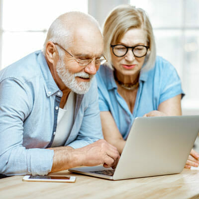 A woman and her elderly father review Chelsea Senior Living pricing information.