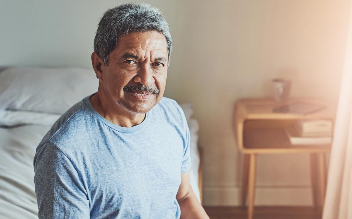 Portrait, retirement and smile of senior man in bedroom of home to relax for assisted living.